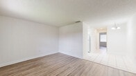 Located at 825 Cypress St in Tarpon Springs, FL, this single-story, one-bedroom, one-bathroom home offers a thoughtfully arranged layout across a compact, efficiently designed floor plan. The living and dining areas flow together seamlessly, featuring light-toned wood-look flooring and crisp white walls that create a bright, clean atmosphere throughout. A textured ceiling adds subtle character to the main living spaces. The galley-style kitchen is finished with white cabinetry, a tile backsplash in soft gray tones, light tile flooring, and white appliances including a range, microwave, and dishwasher. A pantry with louvered doors provides convenient additional storage. The bedroom offers a comfortable, private retreat with the same wood-look flooring, a full-width closet with bi-fold doors, and direct access to a dedicated laundry area housing a stacked washer and dryer unit. The full bathroom is finished in white with tile flooring, a single-sink vanity, and a shower/tub combination. Throughout the home, a consistent neutral palette and tile-to-wood flooring transitions give the space a cohesive, move-in-ready feel well-suited to the sunny Florida lifestyle.