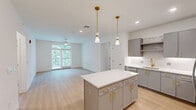 This well-appointed three-bedroom, two-bathroom residence in South Walpole, Massachusetts, offers a thoughtfully designed single-floor layout with contemporary finishes throughout. Light-toned hardwood flooring flows seamlessly across the living areas and bedrooms, creating a clean, cohesive aesthetic.

The open-concept kitchen and living area serves as the heart of the home, showcasing grey cabinetry with gold hardware, a full suite of stainless steel appliances, a tiled backsplash, and a central island with a quartz countertop beneath stylish gold pendant lighting. Recessed lighting adds further brightness to the space.

The primary bedroom is generously sized, featuring large glass doors that invite natural light and offer views of surrounding greenery, complemented by a ceiling fan. It connects to a spa-inspired en-suite bathroom finished with marble-look tile flooring, a dual-sink vanity with gold fixtures, a soaking tub with subway tile surround, a separate glass-enclosed shower, and direct access to a walk-in closet with built-in wire shelving. Additional bedrooms are bright and well-proportioned, with sliding closet doors and clean white walls. A second full bathroom features a tiled tub-shower combination. Two hallways and a dedicated closet round out the practical layout of this modern residence.