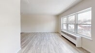 Located at 571 Adelaide St N in London, Ontario, this well-appointed unit offers a thoughtfully organized single-floor layout that maximizes every square foot. The open-concept combined living and dining area serves as the heart of the space, featuring light grey laminate wood flooring that runs throughout, neutral cream-toned walls, and a textured ceiling that adds subtle character. A large multi-pane window floods the main living area with natural light and provides views of the surrounding neighbourhood, while a baseboard radiator ensures comfortable heating year-round. The entrance opens directly into the living space, keeping the layout intuitive and accessible, with two closets providing ample storage. The kitchen is neatly defined and features crisp white cabinetry extending to the ceiling for generous storage, a stainless steel sink, light-toned countertops, and a white electric range. A dedicated window in the kitchen area brings in additional natural light. The bathroom is finished with neutral beige ceramic wall tiles surrounding a full soaker tub and shower combination, complemented by tile flooring for a clean, cohesive look. Throughout the unit, the consistent use of light, neutral finishes creates a bright and airy ambiance that makes the space feel open and welcoming.
