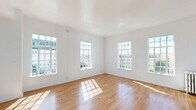 Located on the sixth floor at 840 S Serrano Ave in Los Angeles' Koreatown neighborhood, this one-bedroom, one-bathroom unit offers a well-organized layout with warm hardwood flooring throughout. The spacious primary bedroom is generously sized, bathed in natural light through large, multi-pane windows that frame views of the surrounding cityscape. Crisp white walls and smooth ceilings enhance the bright, airy feel of the living spaces.

The galley-style kitchen is thoughtfully designed with white shaker cabinetry accented by gold hardware, dark stone countertops, a stainless steel refrigerator, gas range, and a double sink — offering a clean, modern aesthetic in a compact, efficient footprint. An adjoining dining room provides a dedicated space for meals.

The bathroom features a soaking tub framed by striking navy blue subway tile wainscoting, with a window above that brings in natural light and city views — a classic yet stylish detail. The unit also includes three closets, one of which is outfitted with built-in white cabinetry, gold hardware, and a vanity with mirror, providing excellent storage and organization. The overall ambiance is clean, light-filled, and functional, making thoughtful use of every square foot.