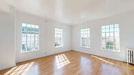 Located on the sixth floor at 840 S Serrano Ave in Los Angeles' Koreatown neighborhood, this one-bedroom, one-bathroom unit offers a well-organized layout with warm hardwood flooring throughout. The spacious primary bedroom is generously sized, bathed in natural light through large, multi-pane windows that frame views of the surrounding cityscape. Crisp white walls and smooth ceilings enhance the bright, airy feel of the living spaces.

The galley-style kitchen is thoughtfully designed with white shaker cabinetry accented by gold hardware, dark stone countertops, a stainless steel refrigerator, gas range, and a double sink — offering a clean, modern aesthetic in a compact, efficient footprint. An adjoining dining room provides a dedicated space for meals.

The bathroom features a soaking tub framed by striking navy blue subway tile wainscoting, with a window above that brings in natural light and city views — a classic yet stylish detail. The unit also includes three closets, one of which is outfitted with built-in white cabinetry, gold hardware, and a vanity with mirror, providing excellent storage and organization. The overall ambiance is clean, light-filled, and functional, making thoughtful use of every square foot.