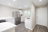Located in the coastal city of San Clemente, California, this single-floor residence on Avenida Del Presidente offers a clean, updated interior with a cohesive neutral color palette throughout. Light wood-style flooring runs across the main living areas, complemented by crisp white baseboards and warm beige walls that create a bright, welcoming atmosphere.

The living room is a standout space, featuring a ceiling fan, a sliding glass door with vertical blinds that invites generous natural light, and direct access to the outdoors. A wall-mounted heating unit provides comfort year-round. The kitchen is well-equipped with stainless steel appliances—including a gas range and a side-by-side refrigerator—white shaker-style cabinetry, light stone countertops, and recessed lighting overhead.

Multiple bedrooms offer comfortable proportions, each with wood-style flooring, neutral walls, and windows fitted with blinds that allow for natural light and privacy. The space includes two bathrooms: one featuring a glass-enclosed walk-in shower with tile accents and brushed nickel fixtures, and a second with a full tub/shower combo and white fixtures. Both bathrooms are finished with white vanities and wood-style flooring, maintaining the home's consistent, updated aesthetic throughout.