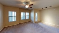 This single-floor residence is thoughtfully designed for comfortable everyday living. The kitchen serves as a functional centerpiece, featuring warm maple cabinetry, light stone countertops, a peninsula with a double stainless steel sink, and a full suite of stainless steel appliances including a range and built-in microwave. Striking red pendant lights and recessed track lighting add a contemporary accent to the space.

The open living area flows naturally from the kitchen via a pass-through peninsula, creating a connected and airy feel. Plush neutral carpeting, ceiling fans with integrated lighting, and multiple windows with blinds fill the room with natural light and offer a comfortable, relaxed atmosphere. A private exterior door provides convenient access.

The bedrooms continue the warm, neutral aesthetic with soft carpeting, ceiling fans, and ample wall space. One bedroom benefits from multiple windows, further enhancing the sense of openness, while the other features a direct connection to the full bathroom.

The bathroom is well-equipped with a vanity featuring marble-style countertops, warm wood cabinetry, a tub-shower combination with decorative tile accents, and generous mirror and overhead lighting. A dedicated utility alcove nearby includes washer/dryer hookups and an electrical panel, adding to the overall practicality of this well-rounded living space.