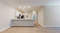 Located at 14735 Stable Gate Place in Louisville, Kentucky, this single-story, 3-bedroom, 2-bathroom home offers a thoughtfully designed layout with modern finishes throughout. Light-toned luxury vinyl plank flooring flows consistently across the entire home, creating a cohesive and clean aesthetic.

The open-concept kitchen and living area serves as the heart of the home. The kitchen features white shaker-style cabinetry, granite-look countertops, stainless steel appliances including a microwave and refrigerator, and a peninsula with a built-in sink — ideal for both meal prep and casual dining. Recessed lighting illuminates the space efficiently.

The spacious living room benefits from a large sliding glass door that invites natural light and provides outdoor access. A ceiling fan adds comfort to this generous gathering space. The hallway connects the living areas to the private bedroom wing, where three well-sized bedrooms await. Each room features neutral-toned walls, windows with blinds, and ample closet storage. The primary bedroom includes a ceiling fan and a generous closet. Additional bedrooms offer built-in closet shelving for organized storage.

Two full bathrooms serve the home, including a tub-shower combination. The neutral color palette and clean, modern panel doors throughout contribute to a bright, move-in-ready atmosphere.