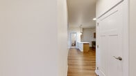 Located at 11684 N Standard Dr in Spokane, WA, this single-floor unit offers 2 bedrooms and 3 bathrooms within a well-utilized floor plan. The entryway opens into a central corridor with hardwood-style flooring that flows throughout the main living areas. The kitchen features warm-toned cabinetry, stainless steel appliances including a full-size refrigerator and range, a peninsula with a white countertop, and a utility sink — providing efficient workspace and storage. The living room is bright and welcoming, with large windows and a glass entry door that invite natural light and offer views of the surrounding greenery. Baseboard heating ensures year-round comfort. The bedrooms are carpeted for warmth and comfort; the secondary bedroom includes a window with outdoor views, while the primary bedroom offers comfortable proportions. The bathrooms are clean and functional, featuring tub/shower combos with white surround panels and hardwood-style flooring. An in-unit laundry area, visible in the floor plan, adds everyday convenience. The layout is thoughtfully organized, making efficient use of the available space throughout the unit.