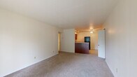 This single-floor, 3-bedroom, 1-bathroom residence offers a practical and comfortable layout designed for everyday living. The open living area features neutral-toned carpet, a ceiling fan, and a sliding glass door that floods the space with natural light and provides direct outdoor access to greenery views. The adjacent kitchen is efficiently designed with rich cherry wood cabinetry, light countertops, tile flooring, and a full suite of black appliances including a refrigerator, range, microwave, and dishwasher, along with a corner sink.

The generously sized primary bedroom includes mirrored sliding closet doors and a dedicated in-unit stacked washer and dryer — a convenient built-in feature. Additional bedrooms are carpeted with natural light from windows fitted with blinds, offering flexibility for various uses. One bedroom also features a sliding glass door for outdoor access.

The bathroom is clean and functional, featuring a full tiled tub-shower combination with chrome fixtures. Throughout the residence, the neutral color palette, consistent flooring choices, and well-maintained finishes contribute to a bright, move-in-ready atmosphere. Hallway access connects all rooms efficiently, completing this thoughtfully organized single-level home.