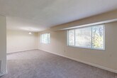 Located at 525 Thayer Ave in Silver Spring, MD, this two-bedroom, two-bathroom residence offers a well-organized single-floor layout designed for comfortable everyday living. The combined living and dining area is generously sized, featuring neutral carpet flooring, soft cream-toned walls, and multiple windows that invite abundant natural light and views of surrounding greenery. A pendant light fixture anchors the dining area, which opens conveniently to the kitchen. The kitchen is outfitted with light wood cabinetry, dark countertops, a stainless steel sink, and wood-look flooring, providing a clean and functional workspace. Both bedrooms are carpeted and well-lit, with windows overlooking outdoor foliage; the primary bedroom includes a ceiling fan for added comfort. Four closets distributed throughout the unit offer exceptional storage capacity. The two bathrooms are efficiently designed — one features a tub-shower combination with sliding glass doors and tile surround, while the other includes a vanity with under-cabinet storage, a mirrored medicine cabinet, and wood-look flooring. A hallway connects the rooms with ease, and an entrance area provides a welcoming transition into the home.