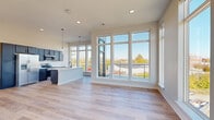 Located at 1410 Breedlove Ln in Indianapolis, IN, this modern 2-bedroom, 2-bathroom home offers a thoughtfully designed single-floor layout filled with contemporary finishes and abundant natural light. The open-concept living, dining, and kitchen area serves as the heart of the home, anchored by dramatic floor-to-ceiling windows that flood the space with sunlight and frame outdoor views of the surrounding neighborhood. Light hardwood flooring runs throughout the main living areas, complementing the clean, neutral color palette. The kitchen is well-appointed with dark navy cabinetry reaching to the ceiling, stainless steel appliances including a French door refrigerator, electric range, and built-in microwave, plus a large center island with a white countertop and undermount sink, all illuminated by sleek pendant lighting. The bedrooms are carpeted for comfort, with the primary bedroom offering generous proportions and natural light. Both bathrooms are finished with dark wood vanities, white countertops, tub-shower combinations with white tile surrounds, and matte black hardware accents. Additional features include a dedicated laundry area, four closets providing ample storage, a hallway, and a welcoming entrance. The overall ambiance is bright, modern, and move-in ready.
