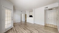 Located at 11300 Expo Boulevard in San Antonio, Texas, this single-floor residence offers a well-organized layout that makes efficient use of its cozy footprint. The open-concept living and dining area serves as the heart of the home, showcasing durable wood-look flooring, crisp white walls, and crown molding that add a clean, polished aesthetic throughout. Natural light filters in through windows, enhancing the bright and airy atmosphere.

The kitchen features a pass-through design with white cabinetry, granite-look countertops, and black appliances including a refrigerator, range, and dishwasher, lending a modern contrast to the light surroundings. Two well-appointed bathrooms include a soaking tub framed by elegant marble-look tile surround, adding a touch of luxury. The bedrooms are comfortably sized, with one featuring a ceiling fan, and both offering access to dedicated closets for ample storage.

Additional conveniences include an in-unit laundry area and a private patio that overlooks a tree-lined outdoor setting, providing a peaceful retreat. The layout flows intuitively from room to room, making the space feel connected and functional. This residence combines practical amenities with tasteful finishes for comfortable everyday living.