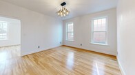 Located on Delmar Boulevard in the heart of University City, this four-bedroom, two-bathroom unit offers a thoughtfully arranged single-floor layout with consistent, modern finishes throughout. Warm hardwood flooring runs continuously across every room, contributing to a cohesive and inviting aesthetic.

The kitchen is well-appointed with light wood cabinetry, stainless steel appliances including a gas range, dishwasher, and a large French-door refrigerator, complemented by a white tile backsplash and a statement sputnik chandelier overhead. A glass block window allows diffused natural light into the space. The kitchen connects openly toward the hallway, enhancing the flow of the layout.

The two living areas provide flexible use of space. The primary bedroom is generously sized, featuring a ceiling fan, a window with exterior views, and ample room. Additional bedrooms receive natural light through double-hung windows and are finished with contemporary geometric light fixtures. One bedroom includes built-in drawer storage.

The bathrooms feature a clean, minimalist design with penny-round tile flooring, marble-style wall tile, a modern vanity with brass accents, and a window for natural light. A hallway connects all rooms efficiently, completing this well-organized and stylishly updated home.