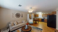 This single-story, 3-bedroom, 2-bathroom home in Katy, TX offers a functional and comfortable layout with a warm, farmhouse-inspired aesthetic. The open-concept living and dining area serves as the heart of the home, featuring light hardwood flooring, neutral warm-toned walls, and a ceiling fan with light fixture. Large windows allow natural light to fill the space, complementing the relaxed, inviting atmosphere. Decorative touches such as a windmill wall accent add rustic character to the living room.

The kitchen is well-equipped with warm oak cabinetry, granite-look laminate countertops, a double-basin stainless steel sink, and black appliances including a range and dishwasher. It flows seamlessly into the dining area, making it practical for everyday living.

The three bedrooms are finished with the same hardwood flooring and neutral walls, each featuring windows with blinds for natural light and privacy. The bathrooms include a vanity with a wide mirror and ample counter space. A dedicated laundry area with a full-size washer and dryer adds everyday convenience. Additional cabinetry and counter space near the laundry area provide useful utility storage, rounding out this practical and well-appointed Katy home.