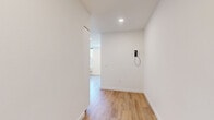 Located in Portland's vibrant SE Milwaukie corridor, this thoughtfully designed one-bedroom, one-bathroom unit offers a clean, modern aesthetic throughout its efficiently laid-out single floor. Light wood-tone flooring runs continuously across every room, lending warmth and visual cohesion to the bright, white interior.

The kitchen features a full suite of stainless steel appliances, including a refrigerator, electric range, built-in microwave, and dishwasher. Sleek white cabinetry with a matching white subway tile backsplash completes the contemporary look, while recessed lighting illuminates the space effectively.

The bedroom is a comfortable, well-proportioned room filled with natural light from multiple windows that frame views of the surrounding neighborhood's mature trees and rooftops. A set of sliding panel closet doors provides ample storage, maintaining the room's clean, uncluttered feel.

The bathroom continues the unit's minimalist design language with a white vanity, wood-tone flooring, and matte black hardware accents that add a refined, modern touch.

A connecting hallway ties the rooms together efficiently. Throughout the unit, recessed lighting, crisp white walls, and consistent flooring create a cohesive, contemporary atmosphere that is both functional and inviting.