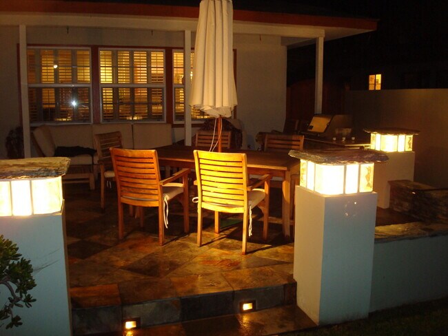 Older photograph showing our patio setup with table and couch along shaded back wall - 5332 Mesmer Ave