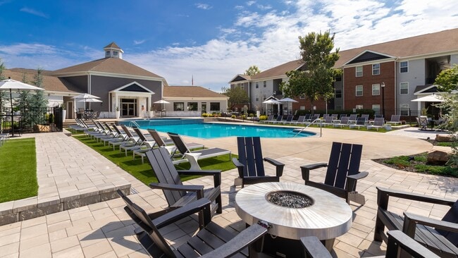 Relax poolside with comfortable chairs and table seating for entertaining and lounging, professionally operated by Highlands Vista Group. - The Foundry