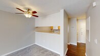Located at 601 Friendway Rd in Greensboro, NC, this single-floor residence offers a functional and comfortable layout designed for everyday living. The open living area is finished with neutral-toned carpet and features a ceiling fan with light fixture, creating a bright and airy atmosphere. Natural light filters in through a large window, enhancing the welcoming feel of the space. A textured ceiling adds a classic touch throughout the main living areas.

The kitchen is connected to the living space via a convenient pass-through counter, allowing for easy interaction between rooms. It is equipped with light wood cabinetry offering ample storage, a coil-burner electric range, over-the-range microwave, refrigerator, and laminate countertops — providing all the essentials for meal preparation.

The bedroom is generously proportioned, carpeted, and includes a ceiling fan. It connects to a hallway with multiple closet doors, offering notable storage capacity, and leads directly to the bathroom. The bathroom features wood-look flooring, a full-size soaking tub with a shower and curtain rod, and clean white finishes throughout.

Hardwood-style flooring in the entryway and bathroom hallway adds contrast and durability, rounding out a practical and cohesive interior design.