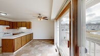 Located at 292 Lakeview Dr in Hartland, WI, this single-floor residence offers three bedrooms, two bathrooms, and a practical, well-organized layout. The open living area is finished with neutral carpet and bright white walls, creating a clean and welcoming atmosphere. Built-in open shelving and a wood-trimmed cabinet unit provide convenient storage without occupying additional floor space. A large sliding glass door floods the living area with natural light and opens onto a balcony with outdoor views.

The kitchen features warm oak cabinetry, light countertops, and tile flooring, complemented by a ceiling fan with light fixture and an adjacent sliding glass door that extends the sense of openness. The generously sized primary bedroom includes plush carpeting, ample natural light from a dedicated window, and sliding wood panel closet doors. The two additional bedrooms are carpeted and well-lit, each offering comfortable proportions.

The two bathrooms are finished with tile flooring and oak-framed mirrors. One bathroom includes a tub-shower combo with a curved rod, while the second features a walk-in style shower with a glass enclosure and built-in shelving for added storage. A hallway and dedicated closet space round out the functional floor plan of this Hartland home.