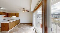 Located at 292 Lakeview Dr in Hartland, WI, this single-floor residence offers three bedrooms, two bathrooms, and a practical, well-organized layout. The open living area is finished with neutral carpet and bright white walls, creating a clean and welcoming atmosphere. Built-in open shelving and a wood-trimmed cabinet unit provide convenient storage without occupying additional floor space. A large sliding glass door floods the living area with natural light and opens onto a balcony with outdoor views.

The kitchen features warm oak cabinetry, light countertops, and tile flooring, complemented by a ceiling fan with light fixture and an adjacent sliding glass door that extends the sense of openness. The generously sized primary bedroom includes plush carpeting, ample natural light from a dedicated window, and sliding wood panel closet doors. The two additional bedrooms are carpeted and well-lit, each offering comfortable proportions.

The two bathrooms are finished with tile flooring and oak-framed mirrors. One bathroom includes a tub-shower combo with a curved rod, while the second features a walk-in style shower with a glass enclosure and built-in shelving for added storage. A hallway and dedicated closet space round out the functional floor plan of this Hartland home.
