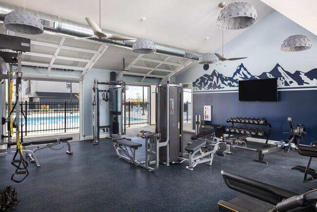 Gimnasio abierto las 24 horas con puertas de garaje para disfrutar del aire fresco - Finley at Baseline