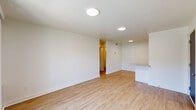 This thoughtfully designed one-bedroom, one-bathroom unit in Tulsa, Oklahoma offers a clean, modern aesthetic throughout its efficiently laid-out single-floor plan. Light wood-style flooring runs continuously through every room, creating a bright, cohesive feel that complements the crisp white walls and trim.

The open living area is well-lit with flush-mount ceiling lights and features sliding glass doors that lead to an outdoor space, allowing natural light to fill the room. Adjacent to the living area, the kitchen is outfitted with white shaker-style cabinetry, granite countertops, a stainless steel sink, a dishwasher, and a gas range — all complemented by a peninsula that provides additional prep and dining space.

The bedroom is a comfortable, well-proportioned retreat featuring a ceiling fan, a natural light window with blinds, and direct access to a dedicated closet with built-in shelving. The bathroom continues the home's clean design with a granite-topped white vanity, a large mirror, and a full tub-shower combination with tiled surround.

A hallway connects the rooms efficiently, and the unit's entry features a bold dark front door. Throughout, the space maintains a fresh, move-in-ready appearance that balances practicality with modern style.