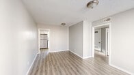 This two-bedroom, one-bathroom unit in Memphis, Tennessee offers a clean, modern aesthetic throughout its single-floor layout. Light-toned luxury vinyl plank flooring runs consistently across all rooms, complemented by soft gray walls, crisp white trim, and textured ceilings that add character overhead.

The living room provides an open, welcoming space with flush-mount lighting and direct sightlines to the kitchen, creating a connected and functional flow. The kitchen is a standout feature, showcasing white shaker-style cabinetry, granite-look countertops, a classic white subway tile backsplash, and a black gas range with overhead ventilation. A stainless steel refrigerator completes the appliance package, while light-filled windows keep the space bright.

Both bedrooms are comfortably sized with neutral gray walls and natural light from windows dressed with horizontal blinds. The primary bedroom benefits from an attached closet, while a second closet provides additional storage elsewhere in the unit. A connecting hallway links the bedrooms to the shared bathroom, which features a full soaking tub with a showerhead, a single-sink vanity, and a frosted window for natural ventilation.

The layout is efficient and well-organized, making practical use of every square foot in this thoughtfully updated Memphis residence.