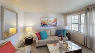 Located at 600 Fifth Ave in Halethorpe, MD, this two-story home offers a practical and well-organized layout spread evenly across two floors. The main level features a bright living room with carpet flooring, natural light from windows with curtains, and a welcoming front entry. The kitchen is well-appointed with warm wood cabinetry, a blue tile backsplash, a gas range, and light hardwood-style flooring. A dining area adjacent to the kitchen benefits from a large window that invites ample natural light. Upstairs, three bedrooms provide comfortable accommodations, including a primary bedroom with a row of horizontal windows offering views of surrounding greenery. The additional bedrooms are cozy and carpeted, each with enough space for standard furnishings. A full bathroom with a tub/shower combination, vanity, and tile flooring serves the home. A staircase and hallway connect the two floors efficiently. The home's neutral color palette throughout creates a clean, versatile backdrop. With its multi-room layout and two-floor design, this residence in Halethorpe provides a structured and livable environment suitable for a variety of occupants.
