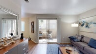 Located at 2200 Standiford Ave in Modesto, California, this single-floor residence offers a thoughtfully organized layout with two bedrooms, two bathrooms, a kitchen, a combined dining and living area, and two closets. The living room features warm hardwood-style flooring, neutral-toned walls, and a textured ceiling, and is anchored by a sliding glass door that floods the space with natural light and provides direct access to a private outdoor patio. The dining area sits adjacent to the living room and is brightened by a large window overlooking greenery, with a ceiling fan adding comfort. The kitchen is outfitted with white cabinetry, granite-style countertops, stainless steel appliances including a refrigerator and dishwasher, and a double-basin sink. Both bedrooms continue the hardwood-style flooring and feature windows with vertical blinds that allow natural light while maintaining privacy. The primary bedroom offers a comfortable, well-proportioned space. Both bathrooms are clean and functional, with one featuring a walk-in shower, white fixtures, and granite-style countertops. Throughout the residence, consistent finishes and a neutral color palette create a cohesive and inviting ambiance.