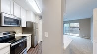 Located at 5664 Walnut Ave in Downers Grove, IL, this well-appointed one-bedroom, one-bathroom unit offers a thoughtfully designed single-floor layout. The open-concept kitchen is a standout feature, boasting white shaker cabinetry, a large quartz peninsula with an undermount sink, and a full suite of stainless steel appliances including a refrigerator, electric range, and microwave. Wood-look flooring runs throughout the kitchen, which also provides convenient access to in-unit laundry. The living room is generously proportioned with plush carpeting, neutral taupe walls, and a full-width sliding glass door that opens to a private balcony, flooding the space with natural light and outdoor views. The bedroom is a comfortable retreat, featuring soft carpet, neutral tones, and two windows that bring in additional daylight. A spacious walk-in closet with wire shelving offers ample storage. The bathroom is clean and functional, featuring a tiled tub-shower combination, a white vanity with a quartz countertop, built-in cabinetry, and wood-look tile flooring. The overall aesthetic throughout is modern and move-in ready, with a cohesive neutral palette.