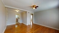This single-floor apartment in Memphis, TN offers a blend of classic charm and modern convenience. The space boasts gleaming hardwood floors throughout the main living areas, complemented by elegant crown molding that adds a touch of sophistication. The living room is spacious and well-lit, featuring a decorative ceiling fan and ample natural light from multiple windows.

The kitchen, while compact, is efficiently designed with wooden cabinets, a checkerboard-patterned floor, and white appliances. It includes a refrigerator, stove, and ample counter space, making it functional for everyday cooking.

The bedroom continues the hardwood flooring theme and features a ceiling fan for comfort. Large windows with blinds allow for plenty of natural light and privacy control. The bathroom is clean and bright, with white tiled walls, a shower/tub combination, and a window for ventilation.

A notable feature is the attention to detail in the finishing touches, such as the ornate ceiling light fixtures and the well-maintained baseboards. The apartment also includes modern amenities like central heating and cooling vents, ensuring year-round comfort.

Overall, this apartment offers a cozy, well-maintained living space that combines classic architectural elements with updated features, creating a comfortable and inviting home environment.