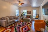 Located at 418 McCallie Ave in Chattanooga, Tennessee, this single-floor residence combines classic architectural character with a warm, lived-in charm. Warm-toned hardwood floors flow throughout the home, connecting each room cohesively.

The entryway is a welcoming hallway lined with framed artwork and practical coat hooks, leading into the main living areas. The living room is a bright, inviting space featuring crown molding, multiple windows that draw in natural light, and a ceiling fan. French doors provide additional access and openness to the room.

The dining room is a standout space, anchored by a built-in arched display cabinet with glass doors and elegant crown molding. A rustic wooden dining table with mixed seating sits beneath a decorative chandelier, with natural light filtering through window blinds.

The kitchen offers ample cabinetry in warm wood tones, a mosaic tile backsplash, tile flooring, a dishwasher, and a pendant light over the sink area. Two bedrooms provide comfortable retreats, each with hardwood floors, ceiling fans, and natural light from windows. The bathroom features classic white tile work surrounding a full bathtub and shower combination. A connecting hallway ties all rooms together, making for an efficient and comfortable floor plan throughout this Chattanooga home.