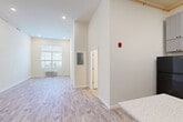 Located at 327 Pine St in Pawtucket, Rhode Island, this 1-bedroom, 1-bathroom unit offers a thoughtfully designed single-floor layout that maximizes functionality. Light-toned luxury vinyl plank flooring flows throughout the space, complementing the crisp white walls and creating a clean, modern aesthetic. The open-concept living and dining area is bright and airy, featuring soaring ceilings, recessed lighting, and a large window that invites abundant natural light. A wall-mounted HVAC unit ensures year-round comfort. The kitchen is well-equipped with gray shaker-style cabinetry extending to the ceiling for ample storage, speckled quartz countertops, a peninsula with additional counter space, and a full suite of black appliances including a refrigerator, electric range, built-in microwave, and dishwasher. The bedroom is a comfortable, well-lit retreat with a large window overlooking the outdoors, a wall-mounted HVAC unit, and access to a closet. The full bathroom features a tub/shower combo, toilet, and vanity with tile-style flooring. Two closets, a dedicated laundry area, and a welcoming entrance complete this efficient and move-in-ready home.