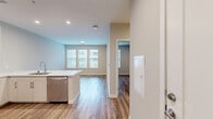 Located at 1900 S Hanover St in Baltimore's South Baltimore neighborhood, this well-appointed one-bedroom, one-bathroom residence offers a thoughtfully designed layout with modern finishes throughout. Wood-style plank flooring runs continuously across the living areas, creating a cohesive and warm aesthetic.

The kitchen is a standout feature, designed with an open-concept flow into the living area. It showcases white shaker-style cabinetry extending to the ceiling, a classic white subway tile backsplash, quartz countertops, and a central island with an undermount sink — ideal for both meal prep and casual dining. Stainless steel appliances, including a refrigerator, range, microwave, and dishwasher, complete the modern look.

The bedroom is a comfortable, well-proportioned retreat with natural light provided by a large window and direct access to a dedicated closet. Neutral wall tones and clean lines give the room a calm, versatile feel.

The bathroom is finished to a high standard, featuring large-format light tile flooring, a sleek vanity with ample cabinetry and a wide mirror, and a glass-enclosed walk-in shower with coordinating tile surround. Recessed lighting adds a polished touch throughout the unit.