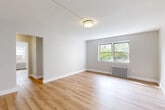 Located in North Bergen, NJ, this well-appointed 2-bedroom, 1-bathroom residence offers a thoughtfully designed single-floor layout with a clean, modern aesthetic. Light-toned hardwood flooring flows consistently throughout, complementing the neutral gray-and-white color palette that gives the space a bright, cohesive feel.

The welcoming entrance leads into a central hallway equipped with a smart thermostat/intercom panel, connecting seamlessly to each area of the home. The spacious living room features large windows that invite generous natural light and views of surrounding greenery, along with a classic cast-iron radiator for warmth.

The updated kitchen is outfitted with stainless steel appliances including a gas range and over-the-range microwave, white cabinetry, subway tile backsplash, and a window overlooking the exterior — making it both functional and well-lit.

Both bedrooms are comfortably sized, each offering natural light through double windows, wood flooring, and cast-iron radiators. The primary bedroom is particularly spacious, with multiple windows providing cross-ventilation and outdoor views. Five closets throughout the unit offer exceptional storage.

The bathroom is a standout feature, finished with floor-to-ceiling marble-style tile surrounding a full soaking tub, complemented by a frosted window for natural light and privacy. The overall ambiance of this residence is clean, updated, and move-in ready.