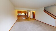 Located at 6909 Chester Dr in Madison, Wisconsin, this multi-level home spans three floors and offers a practical, well-organized layout. The main level features an open-concept kitchen and dining area with warm oak cabinetry, white countertops, light hardwood-style flooring, and standard appliances including an electric range and dishwasher. A staircase with a wooden banister connects the levels, offering views into the main living area below.

The upper level houses two carpeted bedrooms, each brightened by large windows with outdoor views of the surrounding neighborhood. The primary bedroom is generously sized and includes a sliding-door closet. A full bathroom on this floor features oak vanity cabinetry, a tub/shower combination, and light tile flooring. A second bathroom with a wall-mounted mirror and single vanity sink serves additional needs.

The lower level includes a garage, two basement areas with concrete floors — one of which is a utility/storage space with an exposed wood-beam ceiling — offering substantial potential for additional use. Throughout the home, warm wood-toned trim, doors, and accents provide a cohesive aesthetic. With four closets across the home and a multi-floor layout, this property provides functional living space suited for everyday comfort in a residential Madison neighborhood.