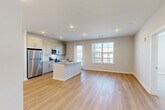 Located at 294 Vision St in Winder, GA, this single-floor, two-bedroom, two-bathroom residence offers a clean, modern design highlighted by light wood-look flooring and neutral tones throughout. The kitchen serves as a central gathering point, anchored by a large island with a granite countertop and undermount sink. White shaker-style cabinetry lines the walls alongside a white tile backsplash, and stainless steel appliances—including a refrigerator, range, and over-the-range microwave—complete the space. A door adjacent to the kitchen provides convenient access to the exterior.

The entry foyer features recessed lighting and a built-in closet, transitioning seamlessly into the living areas. Both bedrooms are carpeted and receive natural light through windows fitted with horizontal blinds, and each room is equipped with a ceiling fan. The primary bedroom connects to a well-sized en-suite bathroom featuring a dual-sink granite vanity, light wood-look flooring, a tiled walk-in shower, and direct access to a spacious walk-in closet with wire shelving. The second bathroom mirrors the same design sensibility, offering a granite vanity and a tiled tub-shower combination. A second walk-in closet provides additional storage throughout the residence.