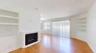 Located at 4824 Craner Ave in the North Hollywood neighborhood of Los Angeles, this single-floor, three-bedroom, one-bathroom home offers a well-organized and functional layout. The living room serves as the heart of the home, featuring warm hardwood-style flooring, a classic fireplace, built-in shelving, and large sliding glass doors that invite abundant natural light and provide outdoor views. An adjacent galley-style kitchen is outfitted with white shaker cabinetry, dark countertops, tile flooring, and a full suite of stainless steel appliances, including a gas range, refrigerator, and dishwasher. The three bedrooms are bright and well-proportioned, each with hardwood-style flooring and large windows that allow natural light to filter in. The primary bedroom features a mirrored sliding closet door and an outdoor-facing window, while the other bedrooms are similarly appointed, with one offering a mirrored closet with built-in shelving. The single bathroom is clean and well-maintained, featuring a combined tub and shower with sliding glass doors, tile flooring, and a vanity with a stone-finish countertop. Throughout the home, a neutral white palette and consistent flooring create a cohesive and inviting atmosphere.