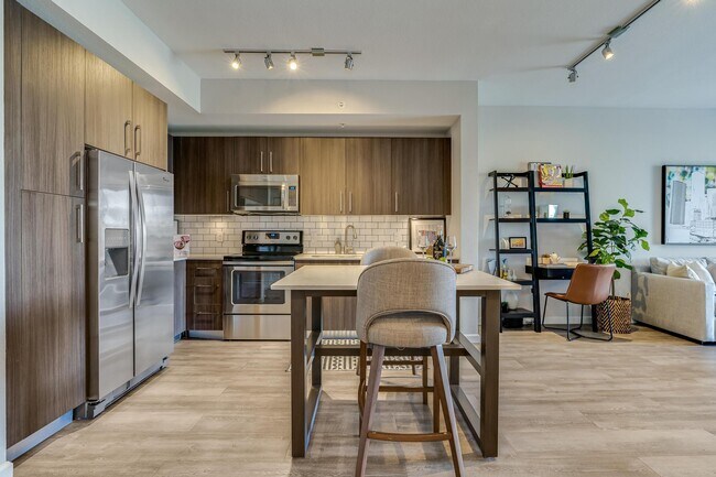 Open Kitchen with Island Seating and View into Living Room - South of Atlantic Luxury Apartments