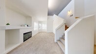 Located at 1350 W Horizon Ridge Pkwy in Henderson, NV, this two-story, one-bedroom, one-bathroom home offers a thoughtfully designed layout spread across two floors. The main level is anchored by a generous open-plan living and dining area featuring plush carpeting, a classic fireplace with a built-in mantle and shelving, and large windows dressed with blinds that invite abundant natural light. The kitchen showcases modern two-tone cabinetry, quartz countertops, a subway tile backsplash, stainless steel appliances including a gas range, and hardwood-style flooring. A laundry area and multiple closets add practical storage throughout. A staircase leads to the upper level, where an open loft with high clerestory windows provides a bright and versatile flex space. The primary bedroom is a comfortable, carpeted retreat with access to ample closet space. The full bathroom features a soaking tub and shower combination. A private balcony extends the living space outdoors. The interior palette throughout is clean and neutral, with white walls and trim creating a light, airy ambiance across every room.