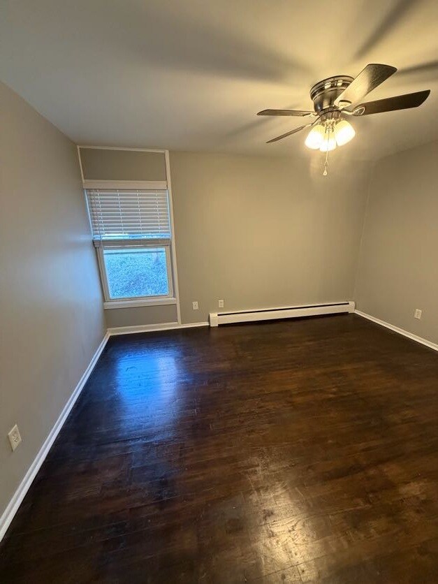 Dormitorio con ventana y ventilador de techo. - Stewart Woods