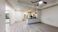 Located in Grapevine, TX, this well-designed single-story, one-bedroom, one-bathroom home offers a functional and modern layout. The open-concept living and kitchen area serves as the heart of the home, featuring light wood-look flooring, a tray ceiling with a ceiling fan, and recessed lighting. The kitchen is outfitted with crisp white cabinetry, dark granite countertops, stainless steel appliances including a refrigerator with ice maker, range, and microwave, plus a peninsula with pendant lighting and a deep sink — ideal for both cooking and entertaining. A built-in desk nook with matching cabinetry provides a dedicated workspace. The spacious primary bedroom features plush carpeting, a tray ceiling, a ceiling fan, natural light from large windows, and double doors leading to a generous walk-in closet. The bathroom includes a dark granite vanity, white cabinetry, a glass-enclosed walk-in shower, and wood-look flooring. A dedicated laundry area accommodates a full-size washer and dryer. The attached garage offers additional storage and convenience. The home's consistent use of neutral tones, granite surfaces, and modern hardware creates a cohesive, contemporary aesthetic throughout.