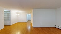 Located at 20 W Montgomery Ave in Ardmore, PA, this single-floor residence offers a thoughtfully laid-out living space with a clean, neutral aesthetic throughout. The open living and dining areas are finished with warm-toned hardwood flooring that reflects natural light, creating a bright and welcoming atmosphere. A chandelier anchors the dining area, while built-in shelving adds a functional decorative touch nearby. The kitchen is well-appointed with honey-toned oak cabinetry, granite-look countertops, tile flooring, and white appliances including a dishwasher and range, providing ample storage and workspace. The bedrooms are generously sized, carpeted for comfort, and each features windows that bring in natural light along with wall-unit air conditioning and baseboard heating for year-round climate control. Two full bathrooms serve the unit; one features a tiled tub-shower combination with a grab bar and vanity, while the second offers a bright vanity with a lighted mirror and tile flooring. The layout, as seen in the dollhouse view, flows efficiently from the main living areas through to the private sleeping quarters, making excellent use of the available space throughout.