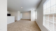 Located at 9103 Renner Blvd in Lenexa, Kansas, this single-floor residence offers two bedrooms and three bathrooms within a thoughtfully organized layout. The open living room features neutral-toned carpet, recessed lighting, and a door leading directly to an outdoor area, complemented by a nearby window that draws in natural light and outdoor views. The kitchen is equipped with warm wood cabinetry, light stone-finish countertops, and includes a stainless refrigerator, providing a practical and functional cooking space with durable hard-surface flooring. Both bedrooms are carpeted and bathed in natural light from windows fitted with blinds. The primary bedroom offers a comfortable footprint with access to a dedicated walk-in closet featuring wire shelving systems for organized storage. The second bedroom also includes its own closet. A dedicated laundry area with hard-surface flooring and utility hookups adds everyday convenience. The three bathrooms include vanities with wood-framed cabinetry, stone-finish countertops, lighted mirrors, and hard-surface flooring. Throughout the residence, a clean, neutral color palette of white walls and light trim creates a bright, cohesive ambiance well-suited for comfortable living.