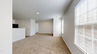 Located at 9103 Renner Blvd in Lenexa, Kansas, this single-floor residence offers two bedrooms and three bathrooms within a thoughtfully organized layout. The open living room features neutral-toned carpet, recessed lighting, and a door leading directly to an outdoor area, complemented by a nearby window that draws in natural light and outdoor views. The kitchen is equipped with warm wood cabinetry, light stone-finish countertops, and includes a stainless refrigerator, providing a practical and functional cooking space with durable hard-surface flooring. Both bedrooms are carpeted and bathed in natural light from windows fitted with blinds. The primary bedroom offers a comfortable footprint with access to a dedicated walk-in closet featuring wire shelving systems for organized storage. The second bedroom also includes its own closet. A dedicated laundry area with hard-surface flooring and utility hookups adds everyday convenience. The three bathrooms include vanities with wood-framed cabinetry, stone-finish countertops, lighted mirrors, and hard-surface flooring. Throughout the residence, a clean, neutral color palette of white walls and light trim creates a bright, cohesive ambiance well-suited for comfortable living.