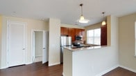 Located at 1001 Haynes Ln in Holly Springs, NC, this single-floor residence offers a thoughtfully designed layout with functional living spaces and quality finishes throughout. The kitchen serves as a central highlight, featuring rich cherry wood cabinetry, granite countertops, a decorative mosaic tile backsplash, and a full suite of stainless steel appliances including a refrigerator, electric range, and built-in microwave. A peninsula with a granite overhang provides additional prep space and a casual dining option, while pendant lighting adds a polished touch. The kitchen flows seamlessly into the open living and dining area, which is finished with warm hardwood-style flooring and bright windows that invite natural light. The bedrooms are carpeted for comfort, each equipped with a ceiling fan and windows offering natural light. Generous closet storage is present throughout, including a walk-in closet accessible from one of the bathrooms. Both bathrooms are finished with granite-topped vanities, rich wood cabinetry, and tub-shower combinations with curved curtain rods. A dedicated linen or utility closet with built-in shelving adds further practicality. The overall ambiance is clean, neutral, and move-in ready, with consistent warm-toned walls and quality materials tying the space together cohesively.
