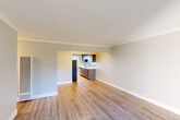 Located at Antoinette Lane in South San Francisco, this single-floor, 1-bedroom, 1-bathroom residence offers a practical and thoughtfully designed layout. The open living room greets you with light hardwood flooring, crown molding, and neutral tones that create a bright and welcoming atmosphere. A sliding glass door leads to an outdoor balcony area, allowing natural light to pour in and offering pleasant views of the surrounding greenery.

The kitchen flows seamlessly from the living area and features warm wood-tone cabinetry, white quartz countertops, a tile backsplash, stainless steel appliances including an electric range and built-in microwave, and a window framing outdoor tree views — ideal for an efficient and functional cooking space.

The bedroom is carpeted for comfort, fitted with a ceiling fan, a large window with outdoor views, and a spacious closet with built-in shelving and hanging rod. An additional open closet provides supplementary storage.

The bathroom is finished with modern wood-grain cabinetry, a white quartz vanity countertop, a large mirror, contemporary chrome light fixtures, and a wall-mounted storage cabinet — creating a clean, cohesive aesthetic. Consistent neutral paint tones and wood-finish details unify the space throughout.