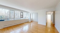 Located at 1641 Bathurst Street in Toronto's Forest Hill neighbourhood, this well-appointed unit offers three bedrooms and three bathrooms across a single thoughtfully laid-out floor. The living areas are characterized by warm hardwood flooring and expansive windows that frame views of mature trees, filling the rooms with generous natural light. Two living spaces provide versatile room for both relaxation and entertaining.

The kitchen is outfitted with white shaker-style cabinetry, dark countertops, a double stainless steel sink, a marble-style subway tile backsplash, and a full suite of appliances including a stove, built-in microwave, and dishwasher. Tile flooring completes the clean, functional aesthetic.

The three bedrooms each feature hardwood floors and windows with outdoor views. One bedroom includes a built-in shelving and cabinetry unit, ideal for storage or a home office setup, while another offers a sliding-door closet. The primary bedroom provides a comfortable and well-proportioned retreat.

The three bathrooms are finished in a clean, contemporary style, with one featuring a white vanity, light tile flooring, a framed mirror, and modern wall-mounted lighting. The ground-floor positioning of this unit offers easy accessibility and views of the treed surroundings.