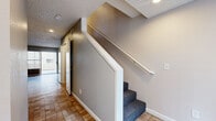 Located at 919 S Lyon St in Santa Ana, CA, this two-story, 2-bedroom, 2-bathroom home is thoughtfully laid out across two well-proportioned floors. The main level features a welcoming entrance that opens to a bright living room and adjoining dining area, all finished with gleaming marble-look tile flooring that lends a clean, polished aesthetic throughout. The kitchen includes a convenient pass-through window connecting to the living space, offering an open and functional design. A carpeted staircase leads to the upper level, where both bedrooms are situated. Each bedroom is finished with wall-to-wall carpet and features vertical blinds that allow natural light to filter in. The primary bedroom includes a sliding-door closet with built-in hanging rods, providing practical storage. An additional closet is also found on the upper floor. Both bathrooms are appointed with warm wood-toned vanity cabinetry, large mirrors, white countertops, and a tub/shower combination with tile surround, finished with neutral tile flooring. The home's interior palette of soft gray and warm beige tones creates a calm, neutral ambiance throughout. The layout is efficient and functional, making excellent use of the space across both floors.