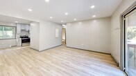 Located at 149 Ashford Center Rd in Ashford, Connecticut, this thoughtfully updated single-floor unit offers a clean, modern aesthetic throughout. Light-toned hardwood flooring runs seamlessly across all living areas, creating a bright and cohesive feel. The open living spaces are illuminated by recessed lighting and feature neutral-toned walls, baseboard heating, and multiple exterior doors — including a sliding glass door that opens to a private balcony with views of surrounding greenery. The renovated kitchen is well-appointed with gray shaker-style cabinetry, granite countertops, a classic tile backsplash, and a full suite of stainless steel appliances including a range, dishwasher, and refrigerator. The bedrooms are comfortably sized, each with windows that invite natural light and views of the lush outdoor landscape. Closet space is present, and the rooms are finished with the same warm hardwood flooring found throughout. The bathroom stands out with its spa-inspired design, featuring a soaking tub, an overhead rain shower, and elegant wall tile combining crisp white panels with rich wood-toned accent strips and a built-in niche. The overall ambiance is clean, modern, and move-in ready.