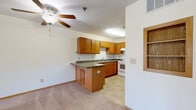 Located at 4768 Golden Pond Ln in Saint Paul, Minnesota, this two-bedroom, one-bathroom single-floor residence offers a functional and comfortable layout. The open-concept kitchen and living area forms the heart of the home, featuring warm oak cabinetry with ample upper and lower storage, dark laminate countertops, a double stainless steel sink, a white electric range, and a peninsula that connects the kitchen to the living space. Tile flooring runs throughout the kitchen, while soft neutral carpet extends into the living room and bedrooms. The living room benefits from a large wood-trimmed window that draws in natural light and offers views of the surrounding greenery. A ceiling fan adds comfort to the space. The primary bedroom is generously proportioned, featuring a wide window with outdoor views and a closet with a full-width wood rod and shelf. The second bedroom is bright and carpeted with ample wall space. The bathroom is well-appointed with a wood-toned vanity, tile flooring, a full tub-shower combination, and a grab bar for accessibility. Throughout the unit, warm wood trim and neutral tones create a cohesive, inviting atmosphere suited for everyday living.
