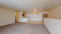 Located at 290 Whispering Springs Dr in Fond du Lac, Wisconsin, this single-floor unit offers a practical and well-organized layout. The open living and dining area is generously sized, featuring neutral-toned carpet, light-colored walls, and a ceiling fan with integrated lighting. A peninsula-style counter separates the living space from the kitchen, which is outfitted with oak cabinetry, dark laminate countertops, tile flooring, a dishwasher, and an electric range with overhead ventilation. The layout provides a smooth transition between living and functional spaces. Two full bathrooms mirror each other in design, each featuring oak vanity cabinetry with dark countertops, tile flooring, and a tub-shower combination. A dedicated laundry room adds significant convenience, housing a full-size washer and dryer alongside built-in wooden shelving for storage, a water heater, and an electrical panel. The tile flooring in utility and wet areas contrasts with the soft carpeting found throughout the main living spaces. Overall, the unit presents a clean, functional design well-suited for everyday living in a quiet residential setting.