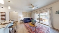 This single-floor residence offers a thoughtfully designed open layout that promotes a seamless flow between the main living spaces. The living room serves as the heart of the home, featuring light wood-style flooring, a ceiling fan, and a large sliding glass door that fills the space with natural light while providing direct access to an outdoor patio with views of the surrounding area. The open design connects effortlessly to the kitchen and dining spaces.

The kitchen is well-equipped with dark espresso-toned cabinetry, granite countertops, a subway tile backsplash, and a full suite of stainless steel appliances. A central island with pendant lighting overhead offers additional prep space and casual seating, making it both functional and social in its design.

The bedroom is a calm retreat, featuring plush carpet, a ceiling fan, and large windows dressed with sheer curtains that allow generous natural light to filter in. An arched entryway adds a subtle architectural detail connecting areas of the unit.

The bathroom is finished with dark wood cabinetry, granite countertops, a large vanity mirror, and a shower-tub combination, complemented by light wood-style flooring that ties the space together cohesively.